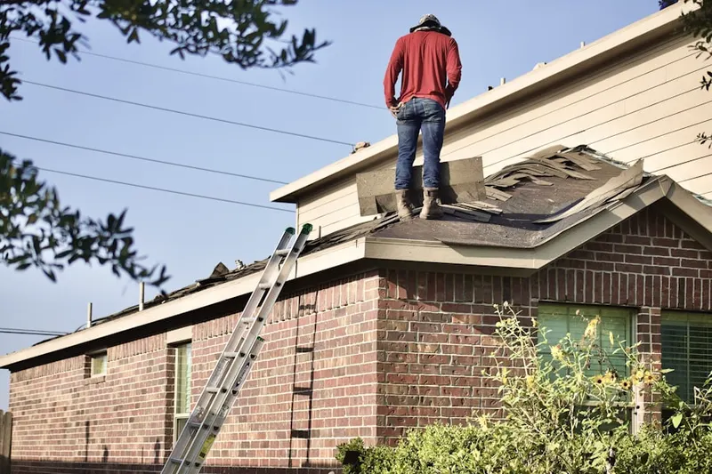 Professional roofer working on a residential roof in Monfort Heights South